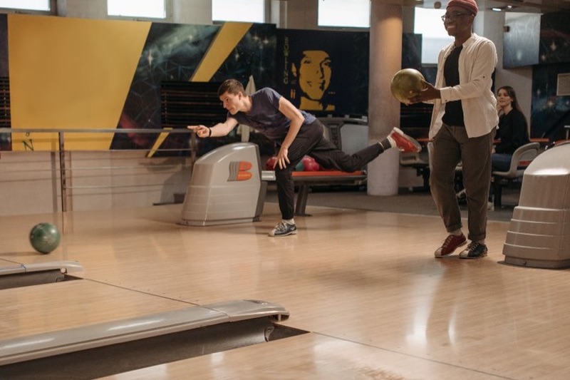 Two friends bowling at an alley