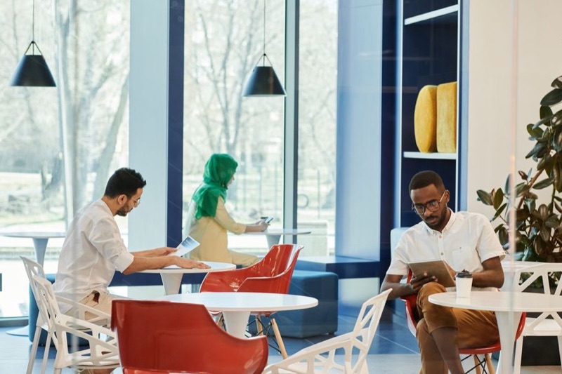 People sitting with drinks at tables in a bright café